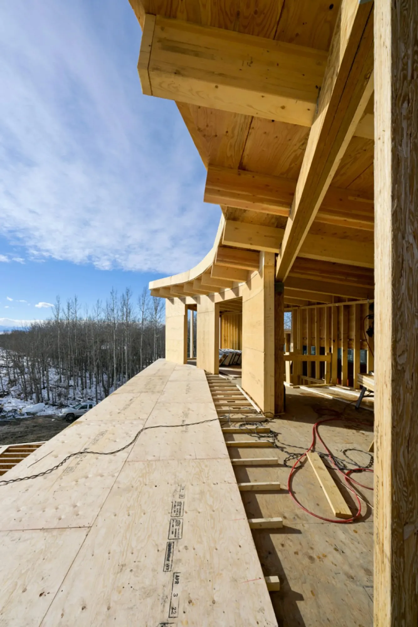 Custom home curved timber roof framing with upper deck
